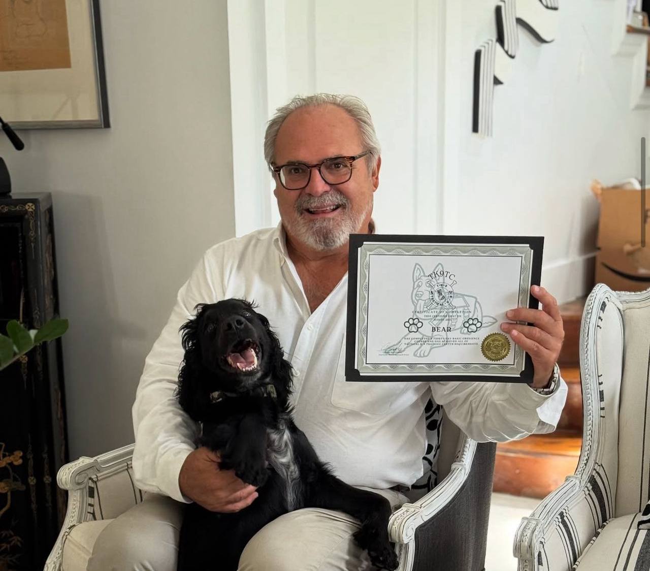 Client holding a Tactical K-9 training certificate with her dog